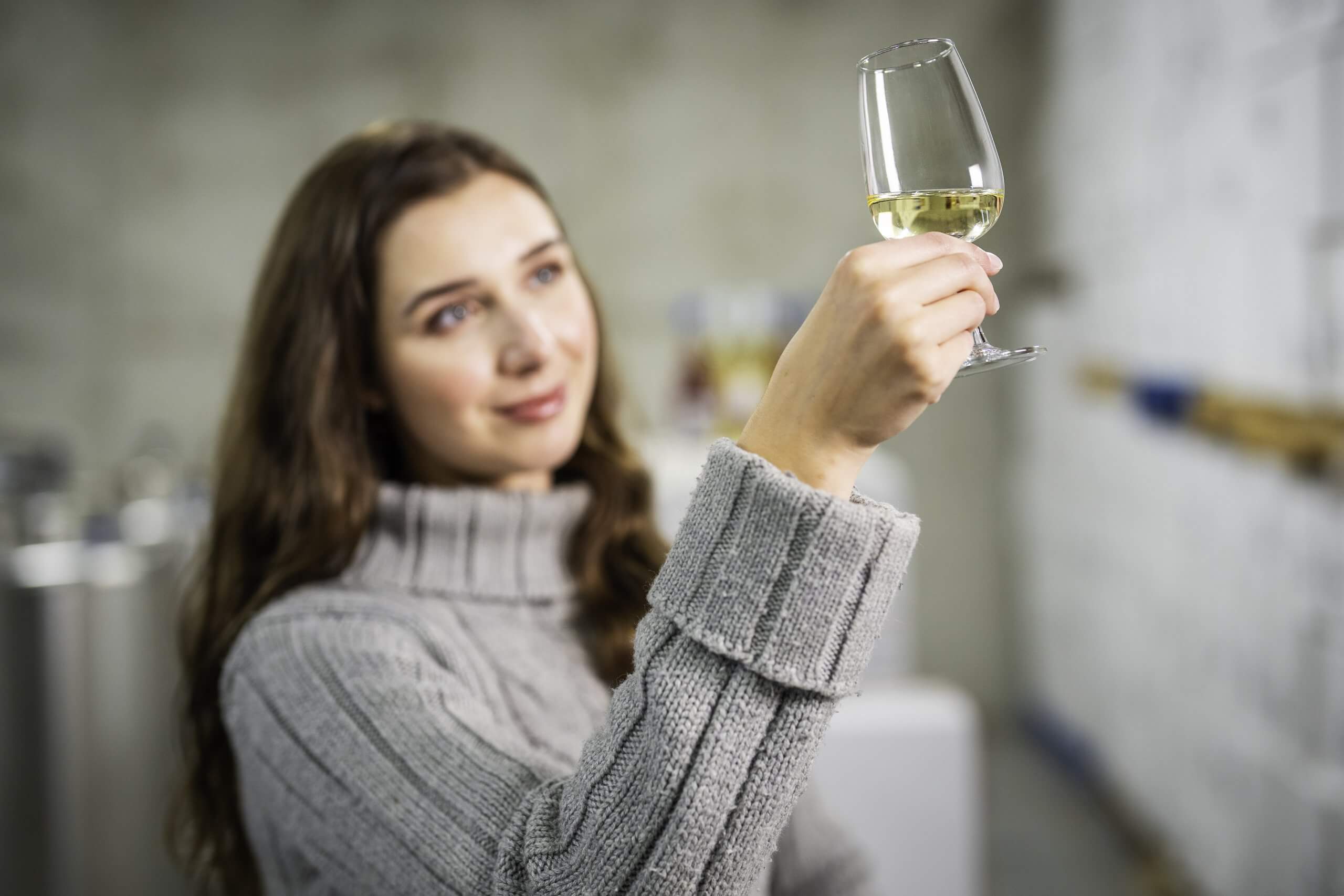 Woman raising a glass in a tasting room