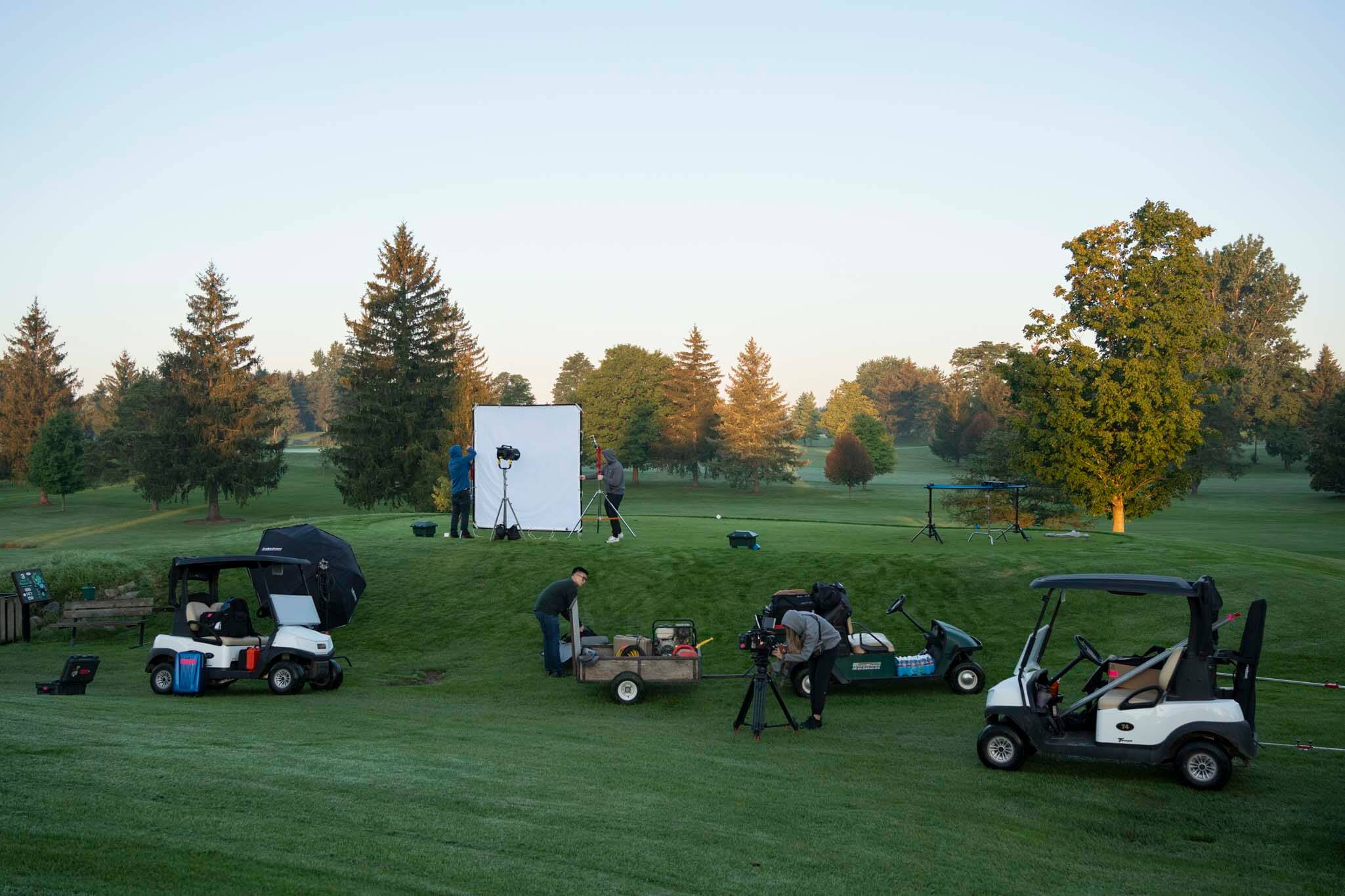 Behind the scenes of a commercial shoot on a golf course at sunrise