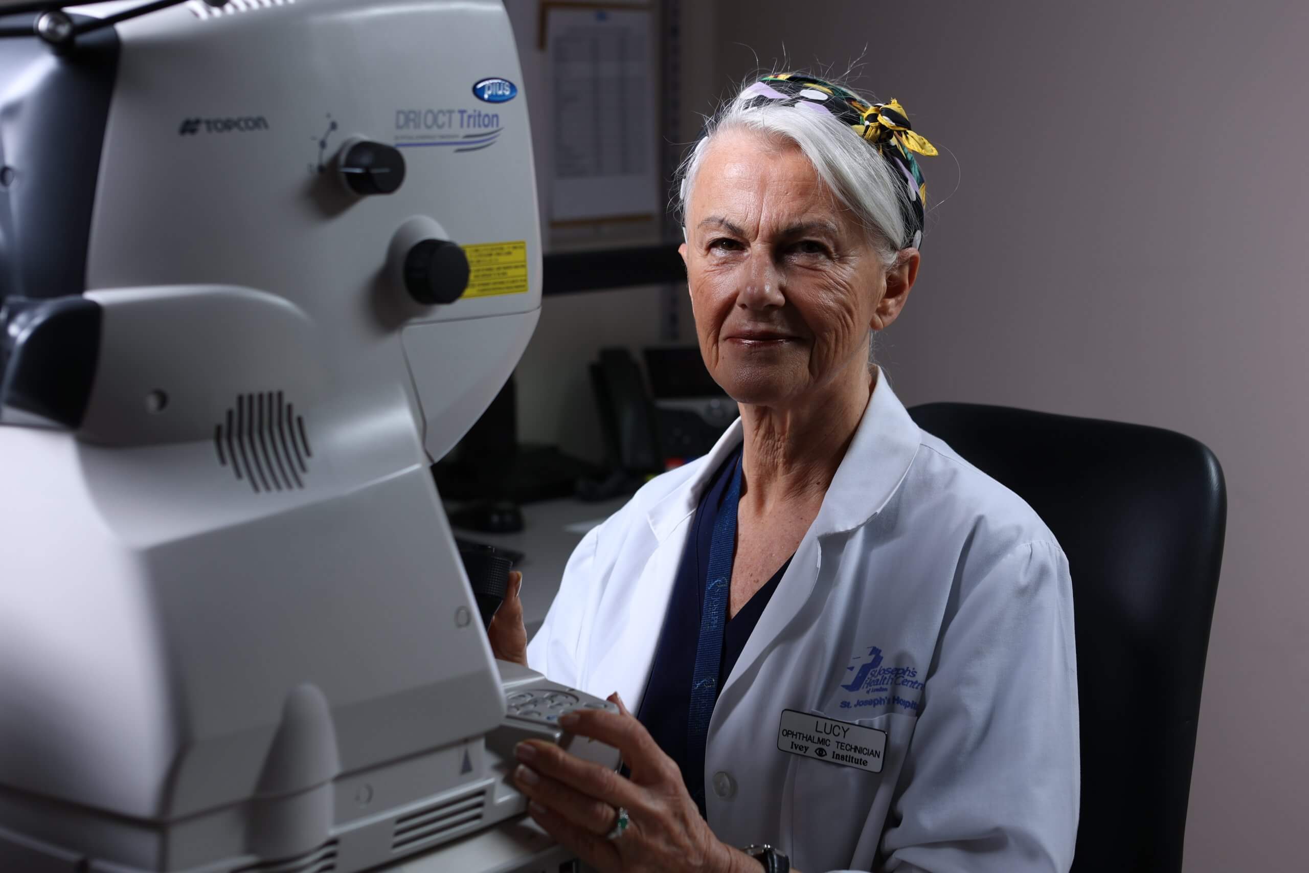 Doctor in a lab coat beside eye-exam equipment