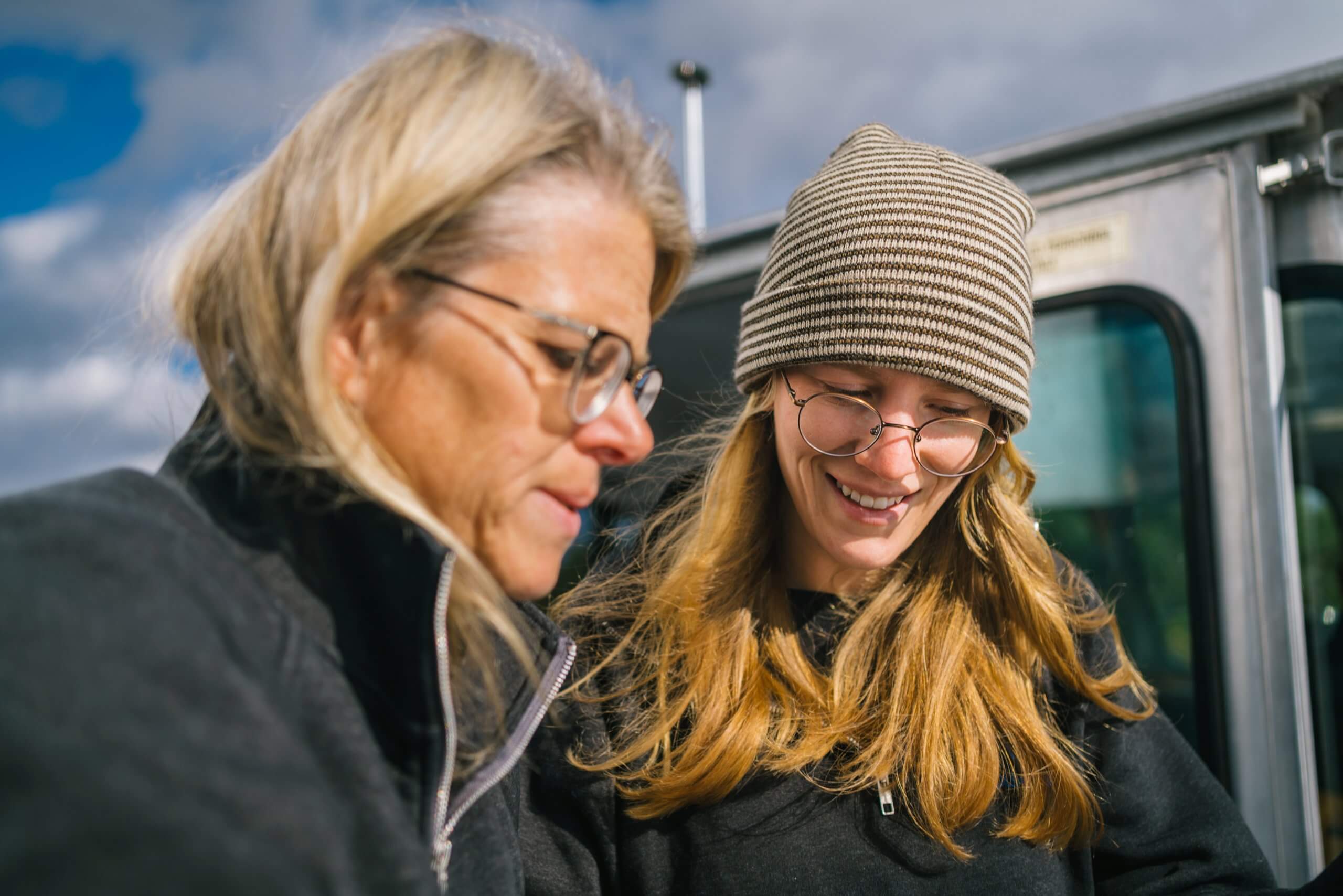 Two women reviewing a tablet outdoors