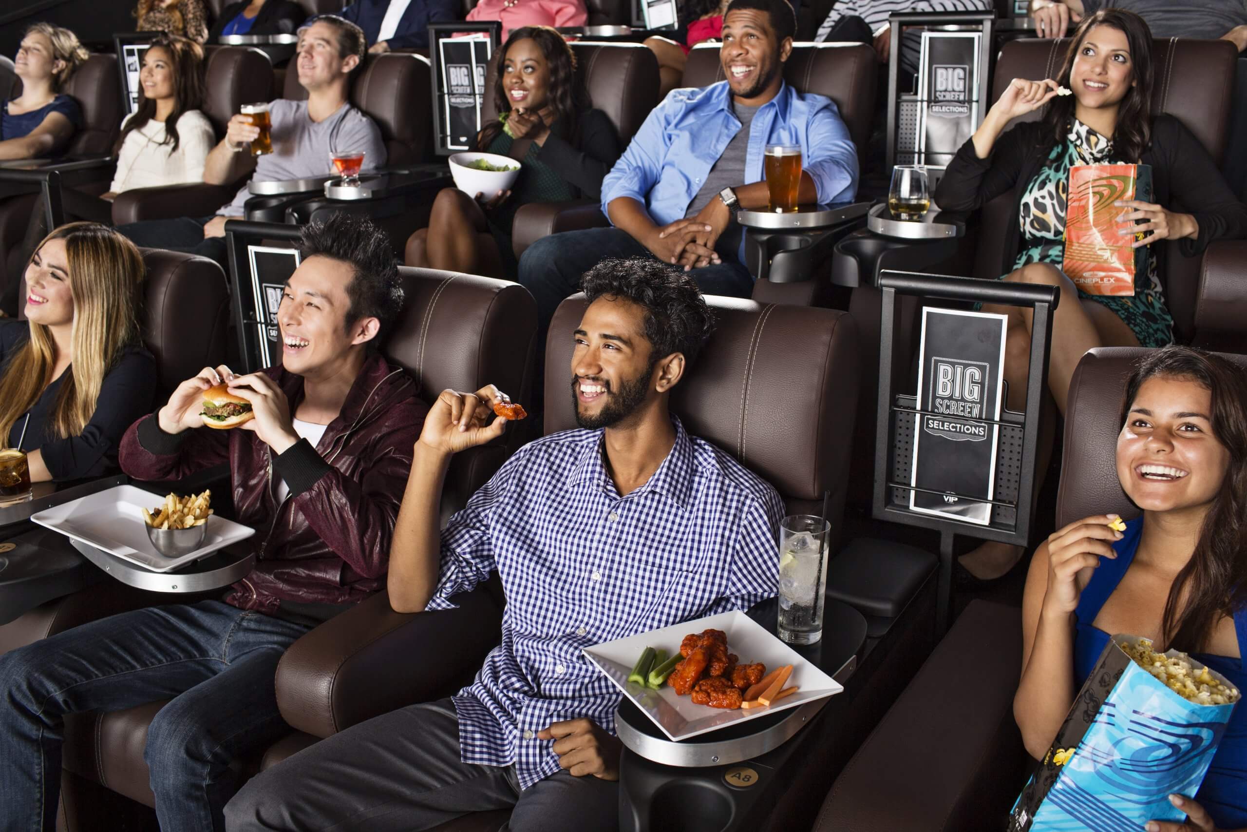 Moviegoers eating in theatre recliners