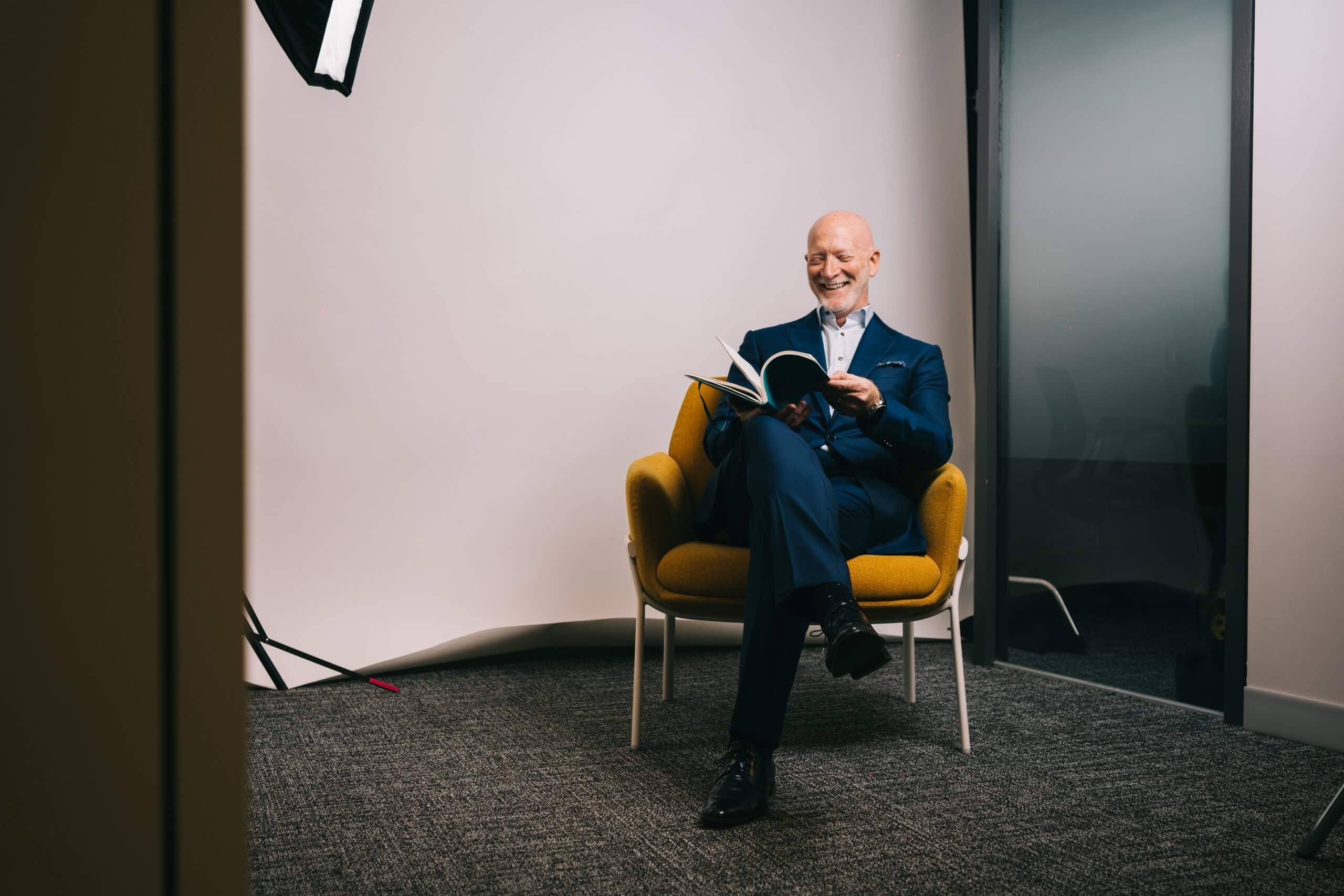 Executive seated in a yellow chair in a studio