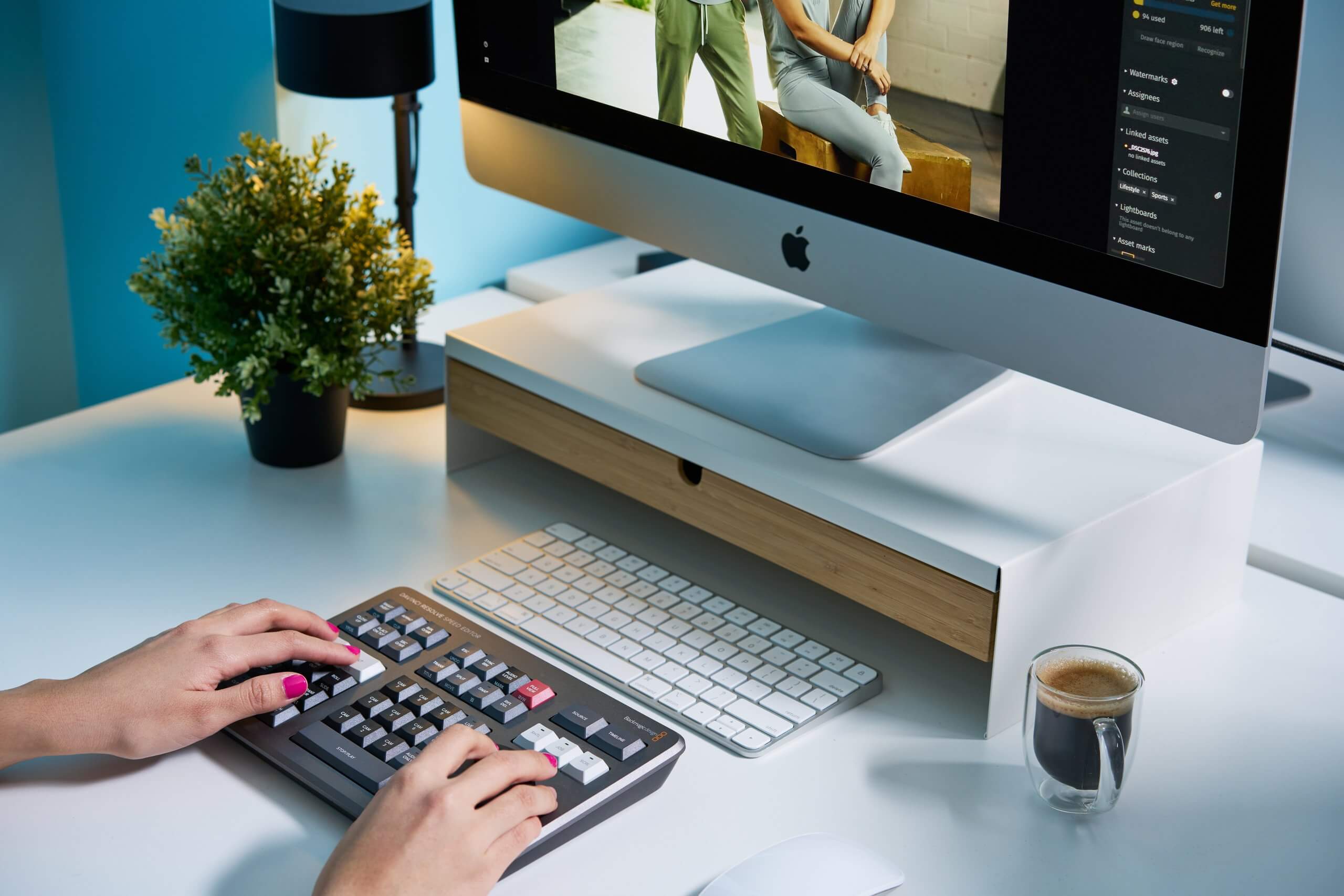 Hands typing at a desk with an iMac