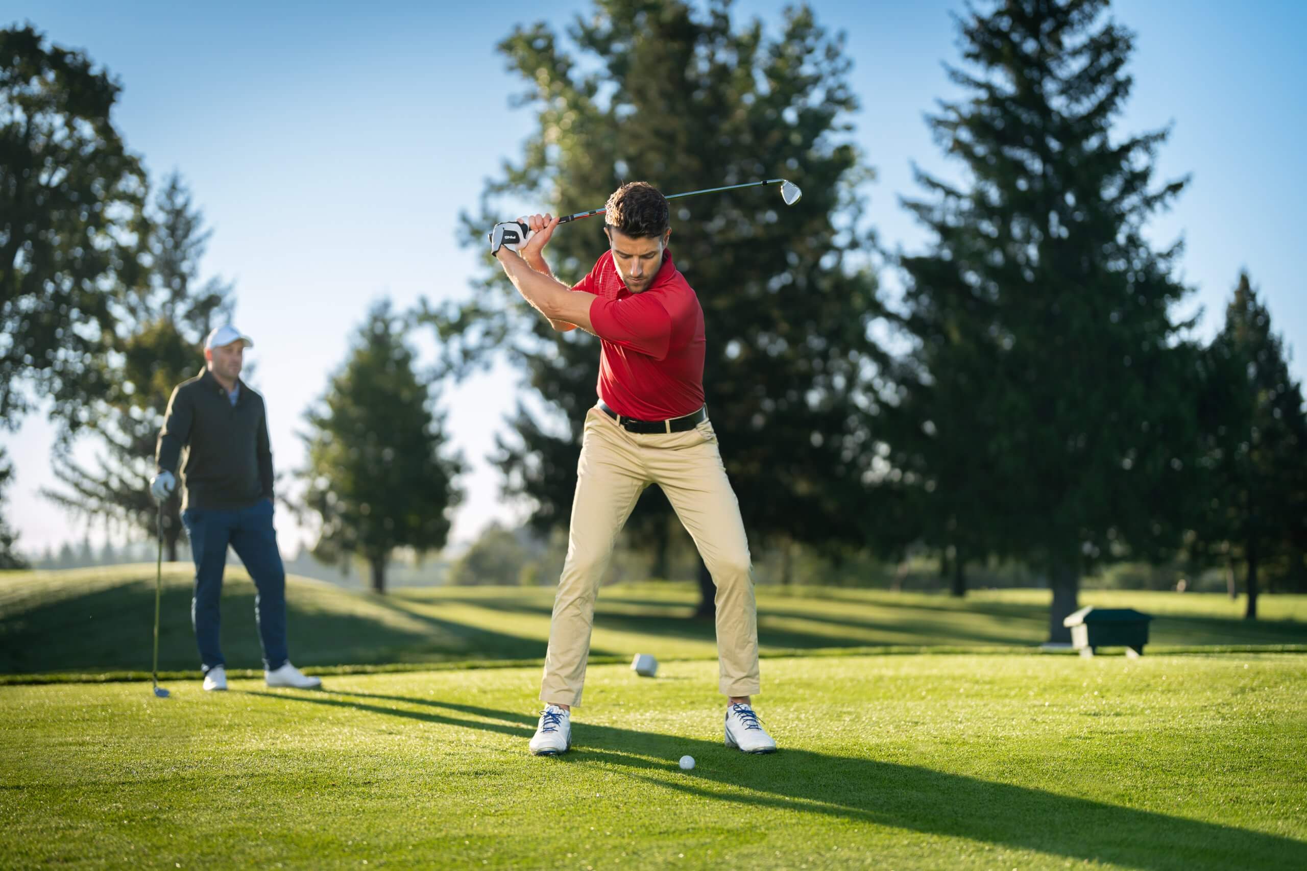 Golfer swinging on a sunny fairway