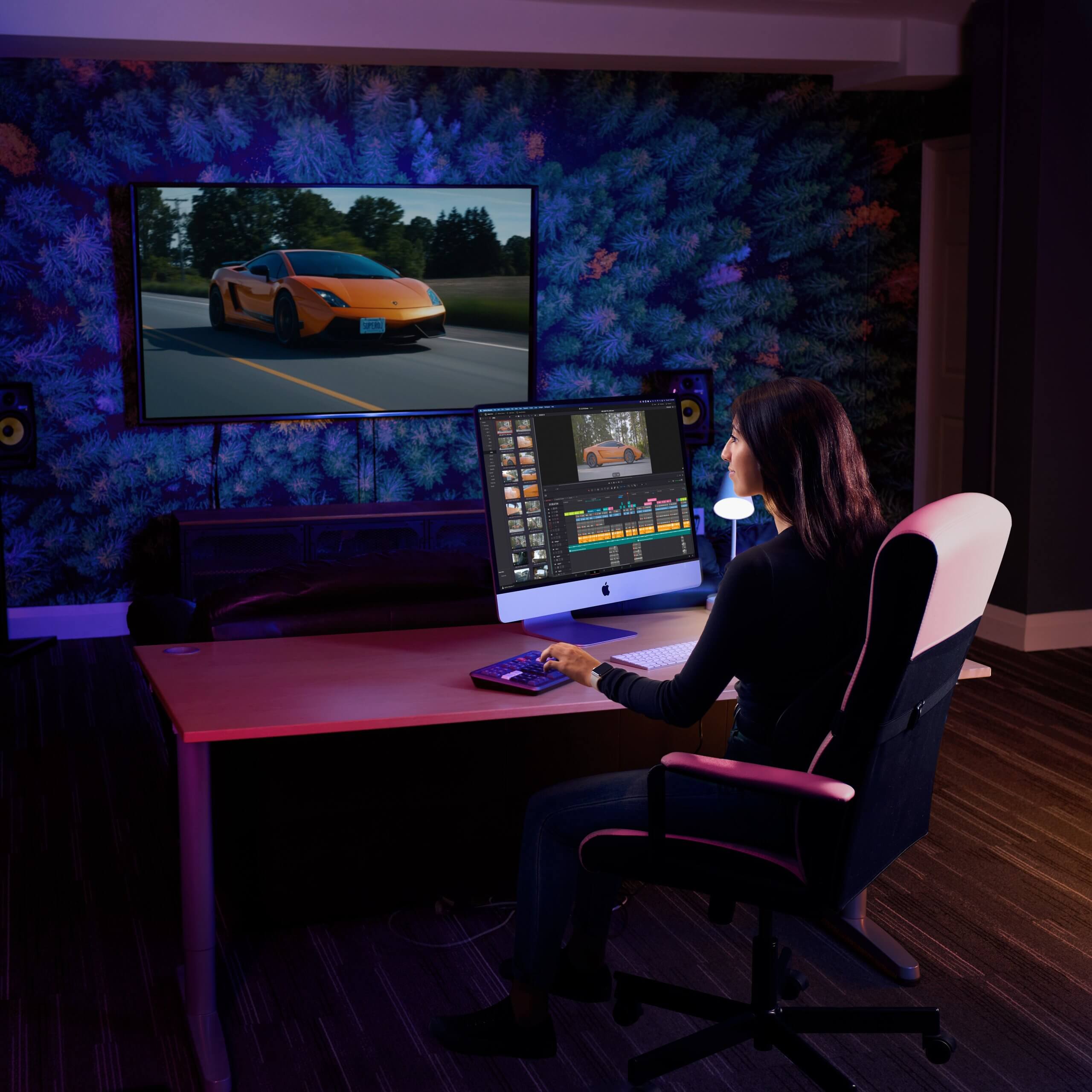 Editor working at a desk in a dark studio