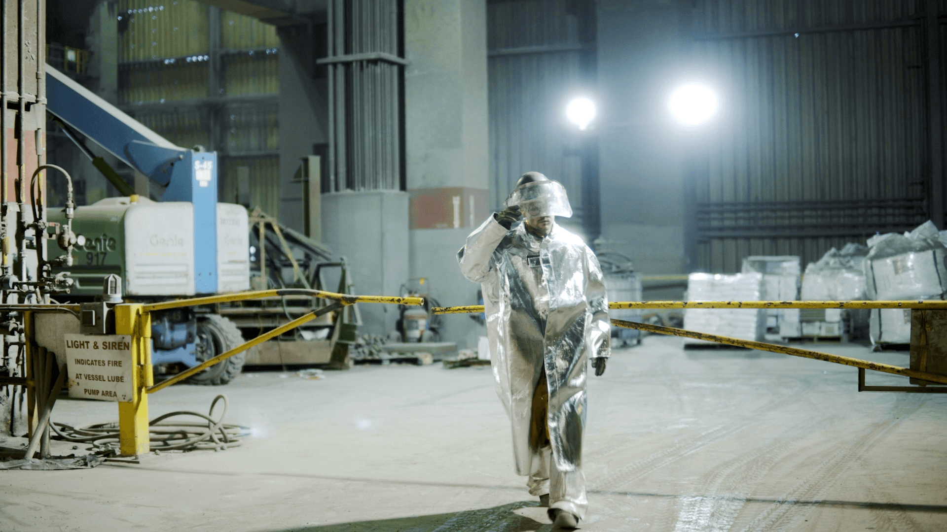 Worker in a heat-protective suit inside a steel mill