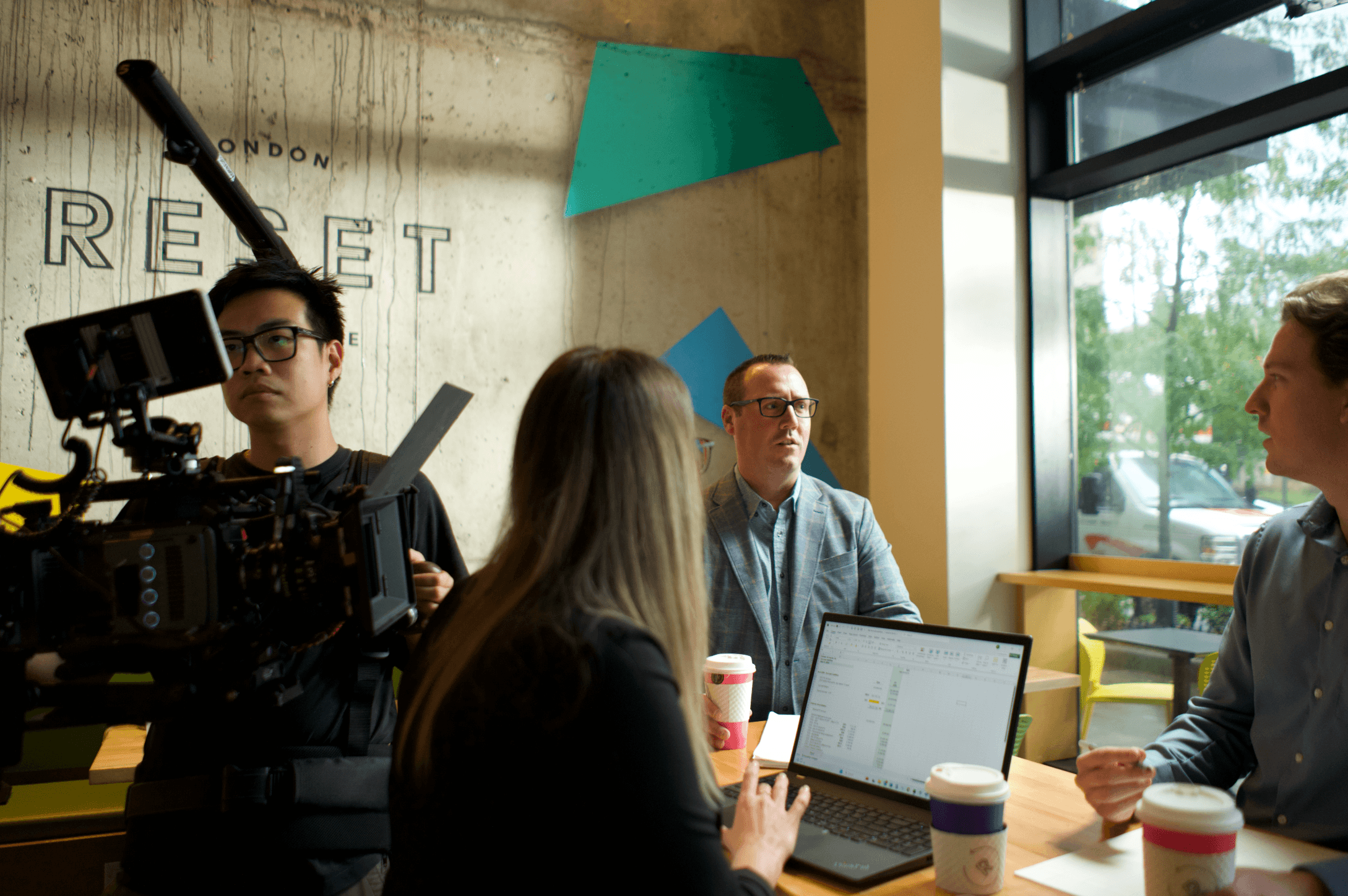 Camera operator filming a meeting in an office